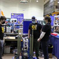 Team members stand in their pit behind their robot